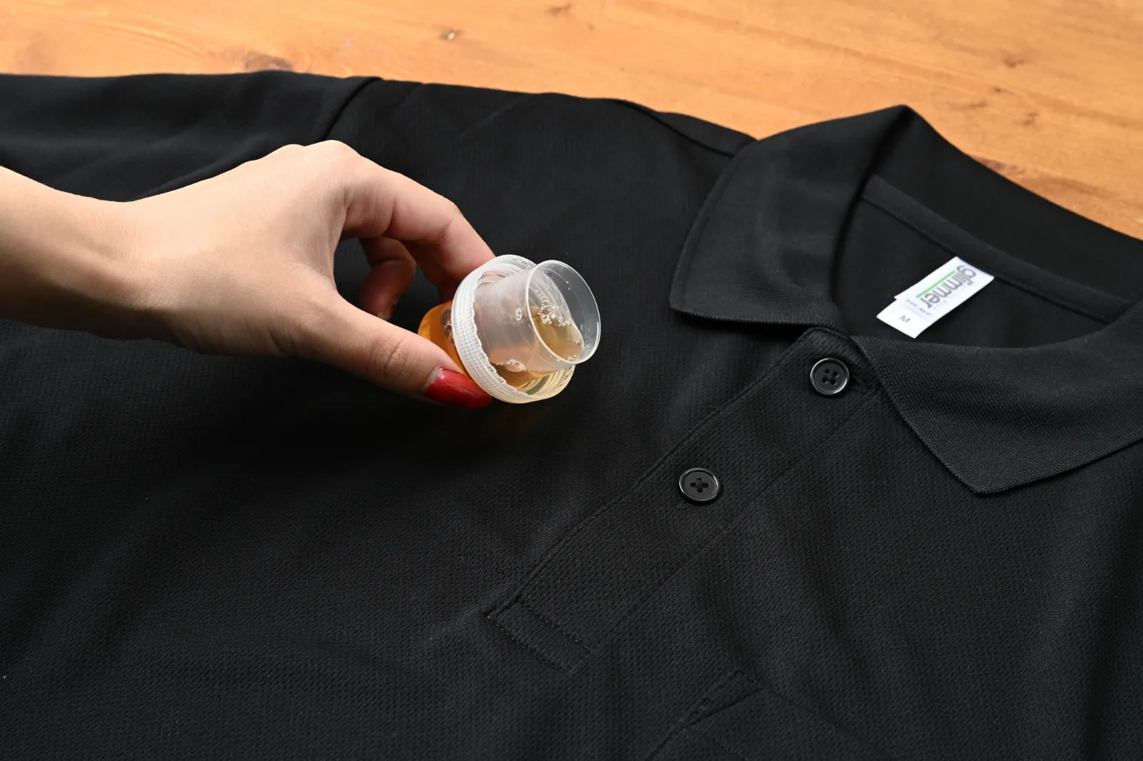 黒いポロシャツに洗剤をかける様子